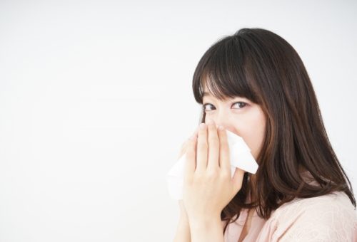 花粉症で鼻をかむ女性